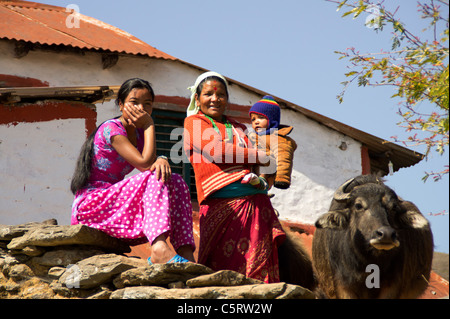 Bauern-Familie mit ihrer Kuh vor ihrem Haus in der Nähe von Pokhara, Western Region, Nepal Stockfoto