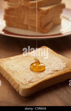 Deutschland, Nordrhein-Westfalen, Düsseldorf, Nahaufnahme von Honig fallen auf Toast Stockfoto