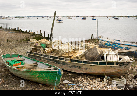 Alte Boote verlassen an der Küste von mersea Island in Essex. Stockfoto