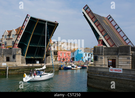 Ein Segelboot durch die geöffneten heben Brücke in Weymouth. Stockfoto