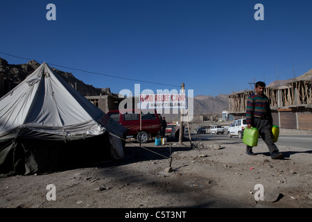 Ein Mann sammelt Wasser von Public Health Engineering Department der Flood Relief Lager in Maney-Tselding, Leh gegeben. Stockfoto