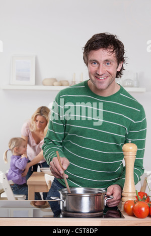 Deutschland, Bayern, München, Vater Kochen mit Mutter und Tochter im Hintergrund Stockfoto
