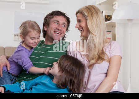 Deutschland, Bayern, München, Familie, sitzen und liegen zusammen, lächelnd Stockfoto