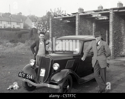 Zwei Männer stehen stolz neben einem Ford Popular in den 1950er Jahren. Stockfoto