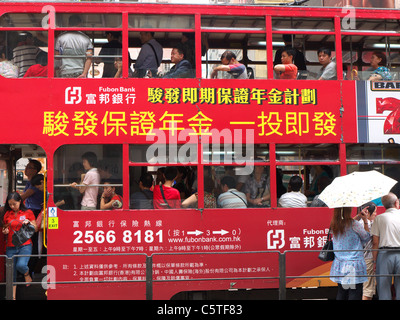 Seitenansicht einer Straßenbahn mit voller Passagiere in den Fenstern in Hong Kong Island hautnah Stockfoto