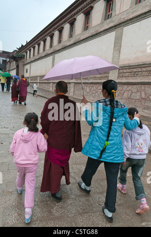 Junge Frauen und buddhistischer Mönch besuchen Kumbum Kloster, Huangzhong, Qinghai Provinz, China Stockfoto