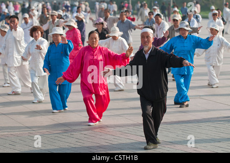 Senioren durchführen am frühen Morgen Tai Chi, einschließlich einen muslimischen Mann in der Stadt Park, Xining, Qinghai Provinz, China Stockfoto