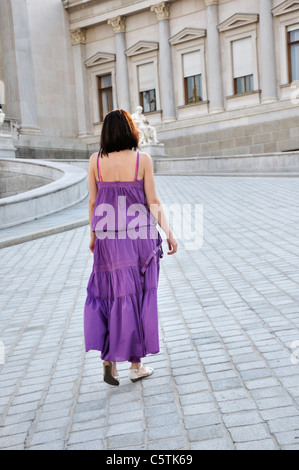 Junge Frau zu Fuß auf gepflasterten Straße zum Parlament Gebäude Wiens Stockfoto