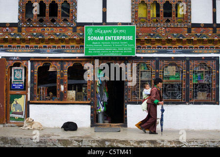 Frau mit ihrem Kind zu Fuß passieren den Shop an Paro-Markt. Bhutan Stockfoto