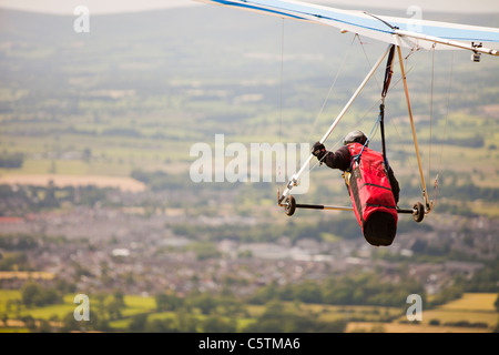 Ein Hängegleiter fliegen von der Seite des Pendle Hill, über Clitheroe in Lancashire, UK. Stockfoto