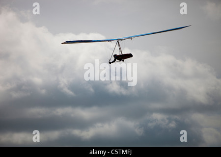 Ein Hängegleiter fliegen von der Seite des Pendle Hill, über Clitheroe in Lancashire, UK. Stockfoto