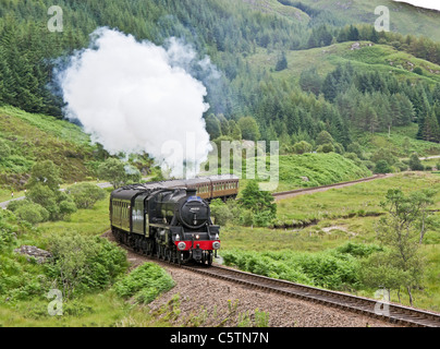 Jacobite Dampfzug fährt bergauf über Glenfinnan Station in Richtung Mallaig an einem sonnigen Sommertag Stockfoto