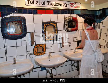 Junge Frau, die Hände zu waschen, in der öffentlichen Toilette Stockfoto