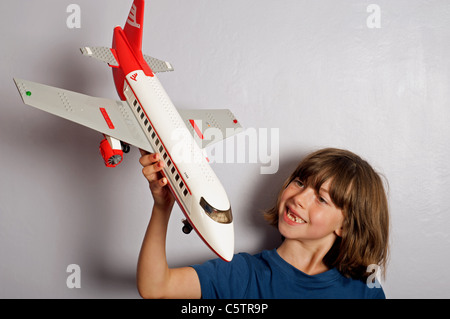 Junges Mädchen (Wildfang) spielen mit ein Lego Modell Jet airliner Stockfoto