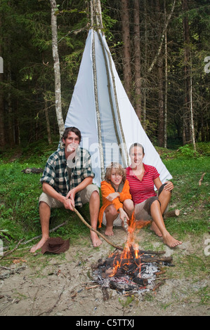 Österreich, Salzburger Land, Familie sitzt am Lagerfeuer Stockfoto