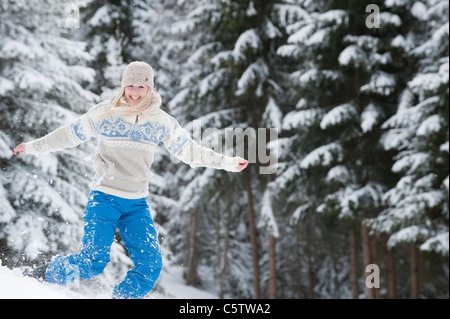 Österreich, Salzburger Land, Altenmarkt, Zauchensee, junge Frau springt in Schnee, Lächeln, Porträt Stockfoto