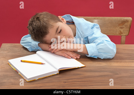 Schüler (6-7) schlafen am Schreibtisch Stockfoto