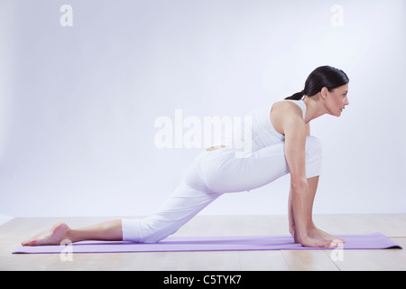 Mitte Erwachsene Frau beim Yoga vor weißem Hintergrund Stockfoto