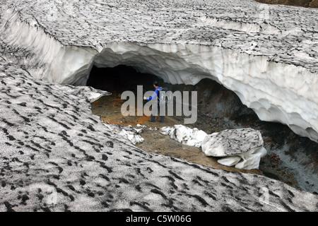 Wanderer auf der Suche in den Eingang der eingestürzten Eishöhle auf dem Laugavegur-Wanderweg Fjallabak Gebiet Islands Stockfoto