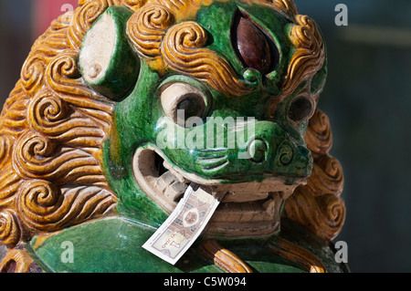 Papiergeld im zeremoniellen Löwenmaul außerhalb Tempeleingang, Sangge Prudence Kloster, Rebong, Provinz Qinghai, China Stockfoto