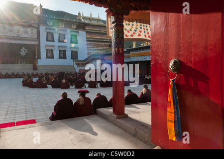 Gelben Hut Sekte tibetisch-buddhistischen Mönche versammeln zum Abendgebet bei Sonnenuntergang, Longwu Kloster, Tongren, Qinghai Province, China Stockfoto