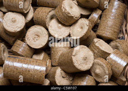 Komprimierte Hackschnitzel- und Sägespäne Pellets in einem Log-Korb bereit sind, einen Haushalt Holzofen macht Stockfoto