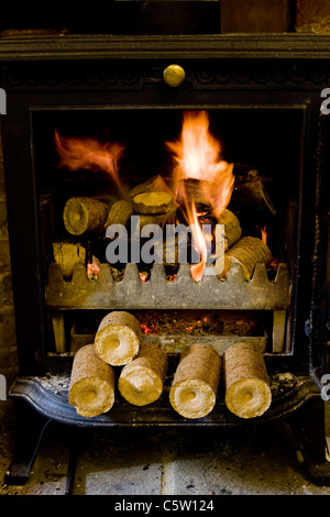 Komprimierte Hackschnitzel- und Sägespäne Pellets in einem Log-Korb bereit sind, einen Haushalt Holzofen macht Stockfoto