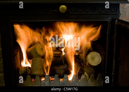 Komprimierte Hackschnitzel- und Sägespäne Pellets in einem Log-Korb bereit sind, einen Haushalt Holzofen macht Stockfoto