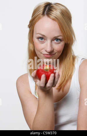 Junge Frau hält einen Apfel Stockfoto