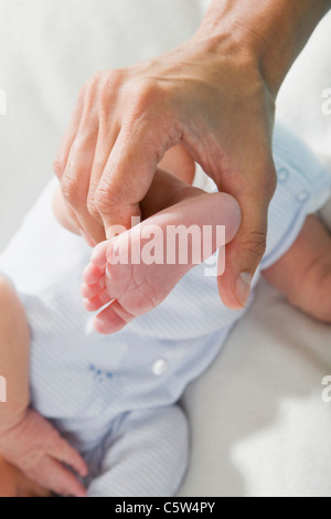 Vater holding Babies (0-4 Wochen) Fuß, erhöhten Blick Stockfoto