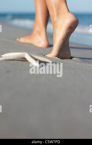Italien, Sardinien, Frau die Füße zu Fuß am Sandstrand Stockfoto