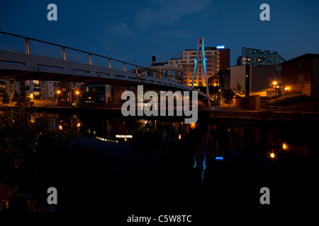 Eine Fußgängerbrücke über die Leeds und Liverpool Canal in Leeds City Centre in der Abenddämmerung Stockfoto