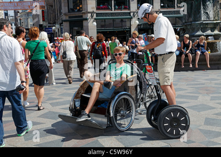 Im Leerlauf Fahrrad Taxifahrer und Segway-Tour guide entspannen unter den Touristen auf Strøget in Kopenhagen an einem warmen und sonnigen Sommertag. Kopenhagen, Dänemark.