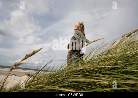 Deutschland, Schleswig-Holstein, Amrum, junge Frau auf grasbewachsenen Sanddüne Stockfoto