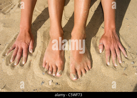 Spanien, Lanzarote, Füße und Hände auf Sand, erhöht, Ansicht Stockfoto