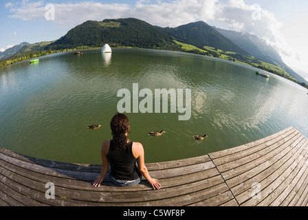 Österreich, Tirol, Walchsee, Frau Entspannung am Wasser, Rückansicht, (fisheye) Stockfoto