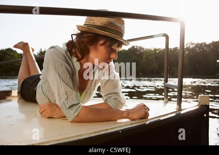 Deutschland, Berlin, junge Frau liegt auf Motorboot Stockfoto