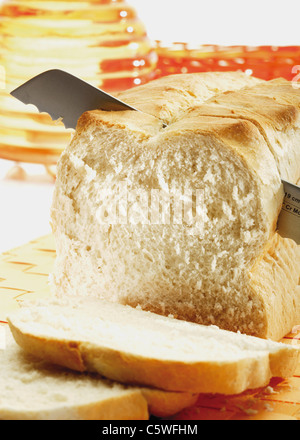 Geschnittenes Weißbrot mit Messer Stockfoto