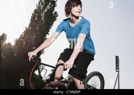 Deutschland, Berlin, Teenage Boy tun Stunt auf Fahrrad Stockfoto