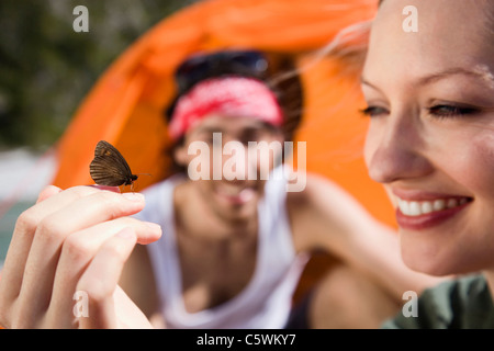 Deutschland, Bayern, junges Paar, camping, Schmetterling ruht auf zarte Frauenhand Stockfoto