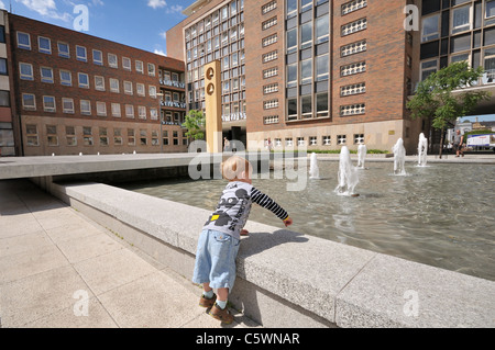 Ein kleiner Junge spielt mit einem Brunnen in der Gemeinde der Stadt Usti Nad Labem, Tschechische Republik Stockfoto