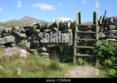 Einen hölzernen Stil über eine traditionelle Trockenmauer In Snowdonia, Wales Stockfoto