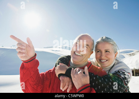 Italien, Südtirol, Seiseralm, Senior paar in Winterlandschaft, Mann zeigen, Porträt, Nahaufnahme Stockfoto