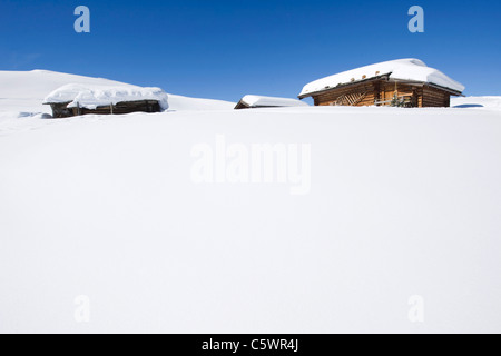 Italien, Südtirol, Seiseralm, Blockhütten in Schneelandschaft Stockfoto