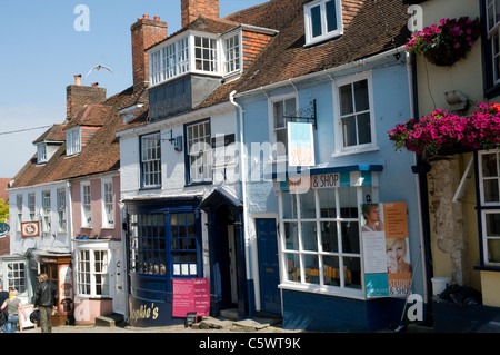 Eine Reihe Geschäfte der alten Linie der Südseite des Hügels steil absteigende Quay in Lymington, Hampshire Stockfoto