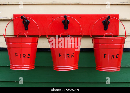 Drei rote Feuer Eimer Wandmontage im Pickering Railway Station, North Yorkshire Stockfoto