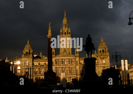 City Chambers, Glasgows öffentlichen Hauptgebäude wird durch starke Abend Sonnenlicht mit dunklen Gewitterhimmel dahinter beleuchtet. Stockfoto