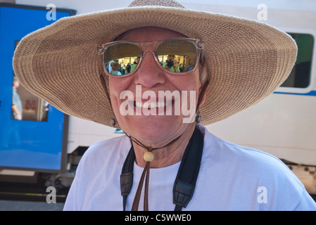 Weibliche amerikanischer Tourist in Vernazza, Italien mit sehr breiter Krempe und reflektierend, spiegelnden Sonnenbrillen, am Bahnsteig. Stockfoto