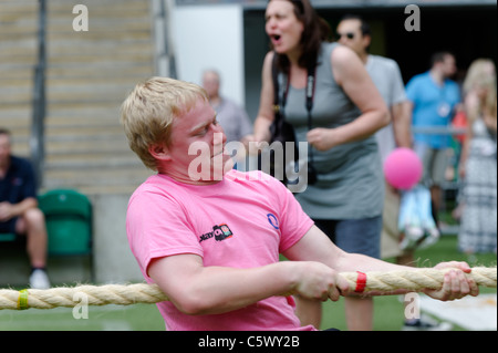 Mann in rosa T-shirt in einem Tauziehen-Wettbewerb konkurrieren. Stockfoto
