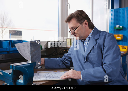 Deutschland, Neukirch, Mann am Arbeitsplatz lesen, Dokumente, Seitenansicht, portrait Stockfoto